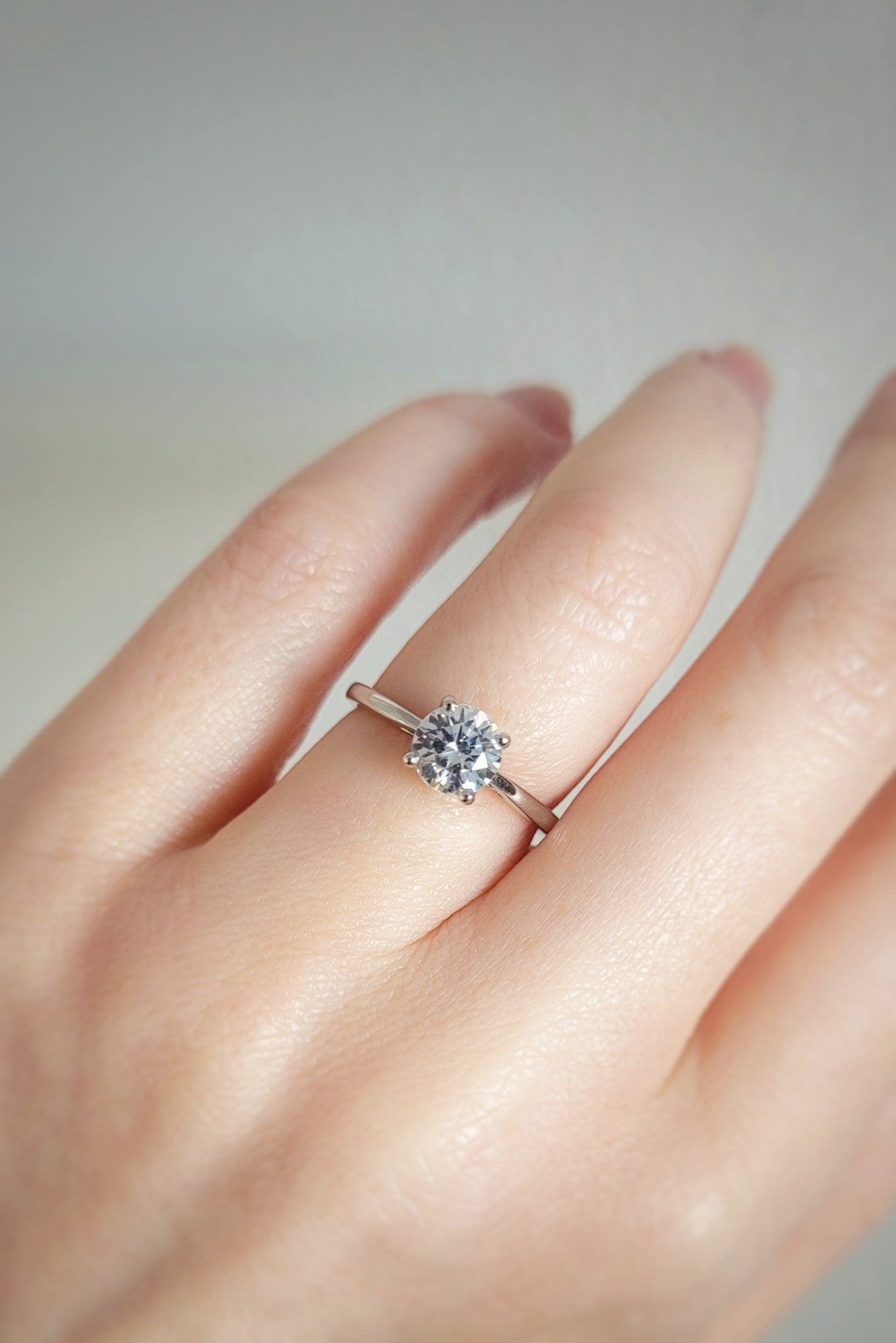 Solitaire diamond engagement ring with Claddagh setting on a models hand